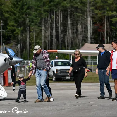 Image shows fly-in attendees walking on the tarmac. 