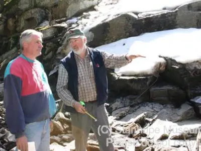 Image shows two members of the construction crew conversing. 