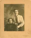 Image shows a portrait of two women with one seated. 