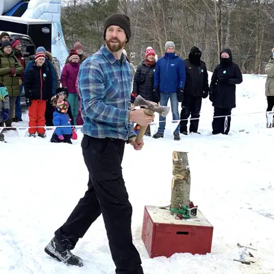 Image shows a man preparing to throw an axe. 