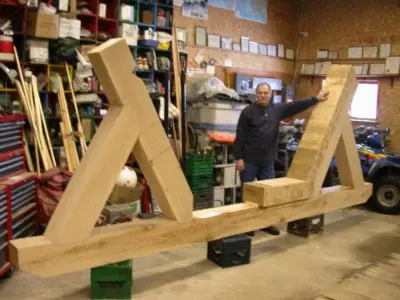 Image shows men working with large timbers. 