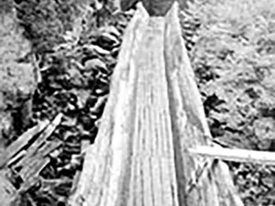 Image shows a black and white photo of the Hawk Lake Log Chute. 