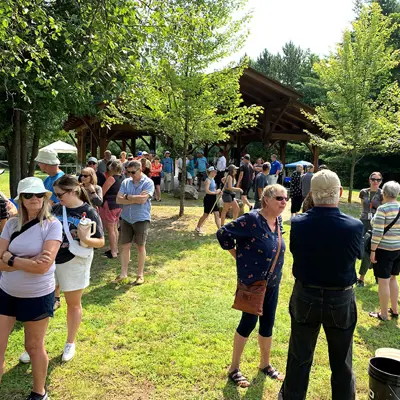 Image shows a crowd of people in a park. 