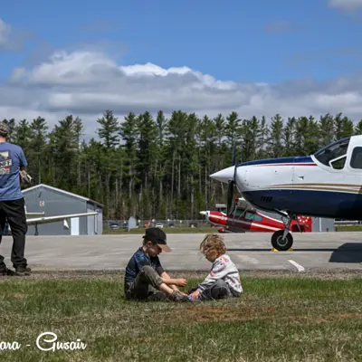 Image shows people and a plane near the airport's taxiway. 