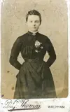 Image shows a picture of a young woman in a black dress. 