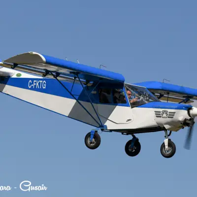 Image shows a blue propeller plane in flight. 