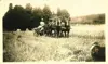 Image shows black and white photo of a man operating horse-drawn farm equipment. 