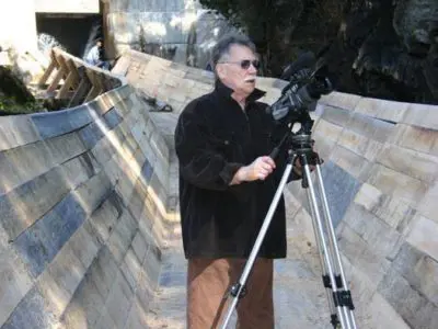 Image shows a videographer standing on the newly completed log chute. 