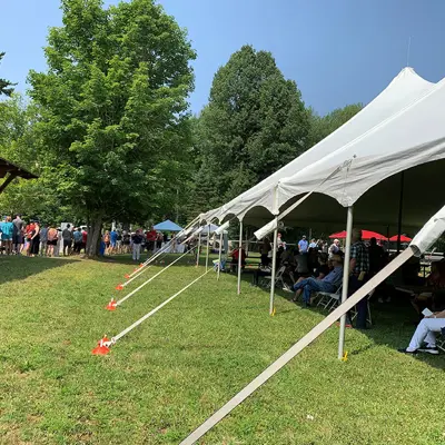 Image shows a large event tent in a park. 