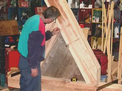 Image shows men working with large timbers. 