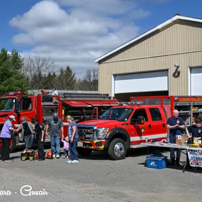 Image shows a crowd looking at Algonquin Highlands Fire Services trucks and equipment. 