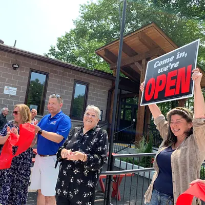 Image shows members of Algonquin Highlands council cutting a ribbon outside the Dorset Recreation Centre. 