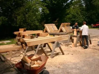 Image shows men working with large timbers. 