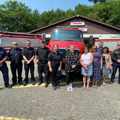 Image shows volunteer firefighters and members of Algonquin Highlands council outside the Dorset fire hall. 