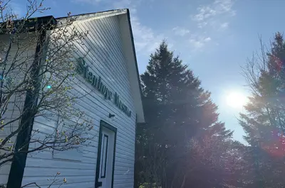 Image shows the Stanhope Heritage Museum with the sun in the background. 