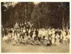 Image shows a black and white photo of an outdoor gathering. 